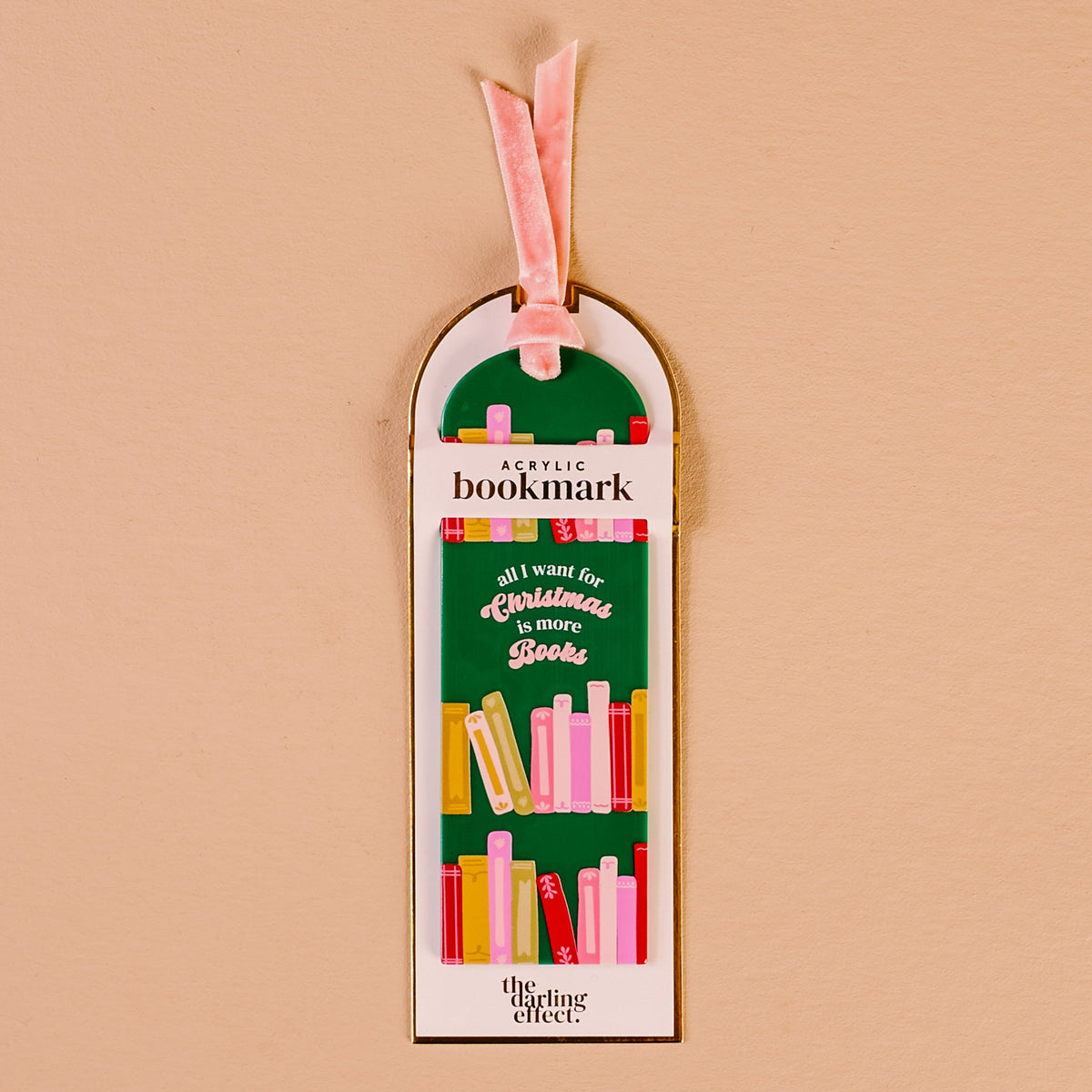 All I Want for Christmas Is More Books Acrylic Bookmark, An acrylic bookmark on its packaging card, printed with book spines and the words all I want for Christmas is more books, tied with a pink velvet ribbon.