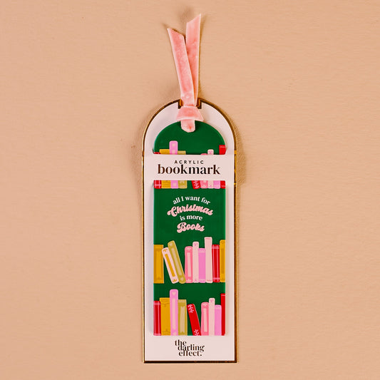 All I Want for Christmas Is More Books Acrylic Bookmark, An acrylic bookmark on its packaging card, printed with book spines and the words all I want for Christmas is more books, tied with a pink velvet ribbon.