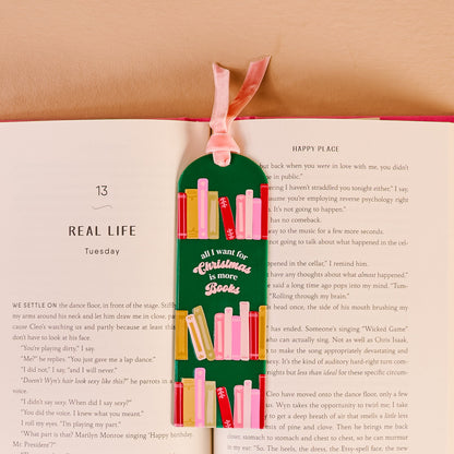 All I Want for Christmas Is More Books Acrylic Bookmark, An acrylic bookmark on its packaging card, printed with book spines and the words all I want for Christmas is more books, tied with a pink velvet ribbon.