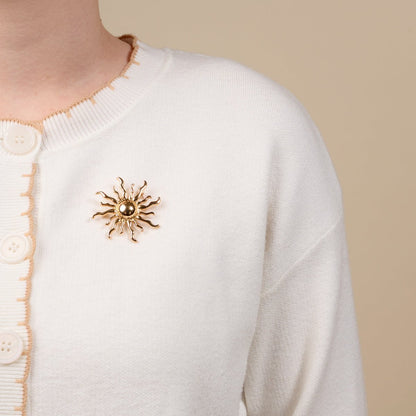 Timeless Brooch, A small gold brooch pin shaped like a teddy bear and covered edge to edge in clear rhinestones, with a gold bow at its neck, shown on a tan background.