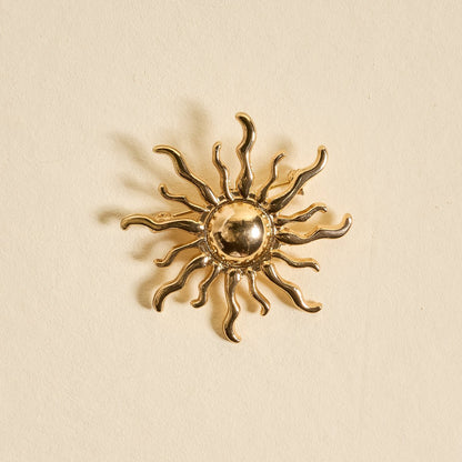 Timeless Brooch, A small gold brooch pin shaped like a teddy bear and covered edge to edge in clear rhinestones, with a gold bow at its neck, shown on a tan background.