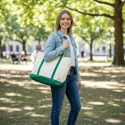 The Signature Canvas Tote Bag, A natural canvas tote bag with black webbing straps, a front pocket, and a gold D-ring, shown against a cream background.