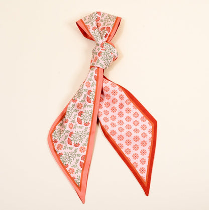 Twirl & Tie Scarf Accessory, A red and white gingham satin scarf tied in a knot, showing a red polka dot pattern on the reverse side of the tails.