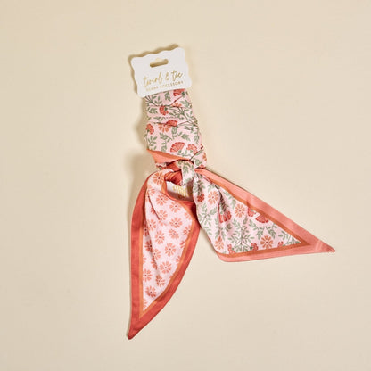 Twirl & Tie Scarf Accessory, A red and white gingham satin scarf tied in a knot, showing a red polka dot pattern on the reverse side of the tails.