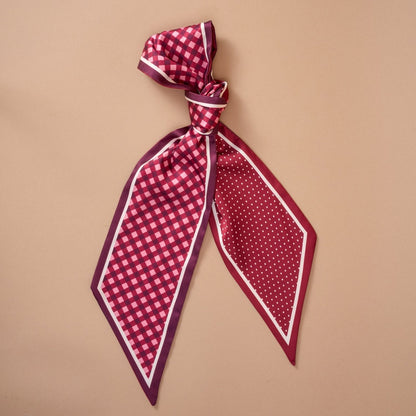 Twirl & Tie Scarf Accessory, A red and white gingham satin scarf tied in a knot, showing a red polka dot pattern on the reverse side of the tails.
