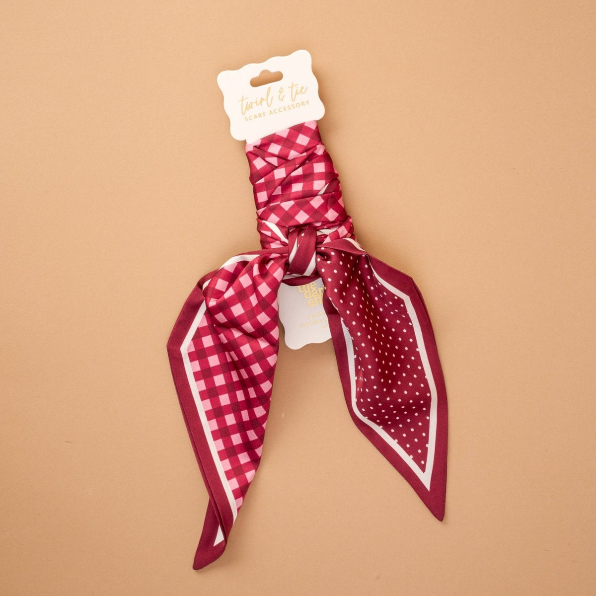 Twirl & Tie Scarf Accessory, A red and white gingham satin scarf tied in a knot, showing a red polka dot pattern on the reverse side of the tails.
