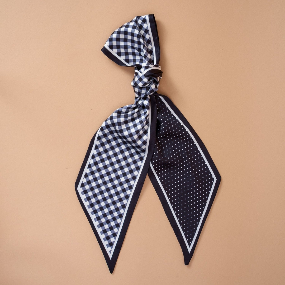 Twirl & Tie Scarf Accessory, A red and white gingham satin scarf tied in a knot, showing a red polka dot pattern on the reverse side of the tails.