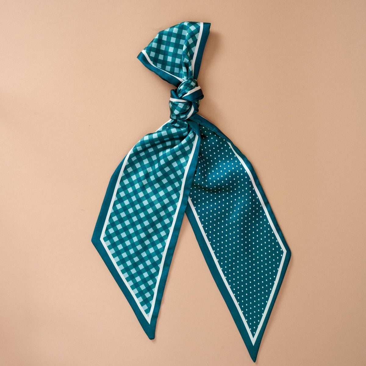 Twirl & Tie Scarf Accessory, A red and white gingham satin scarf tied in a knot, showing a red polka dot pattern on the reverse side of the tails.
