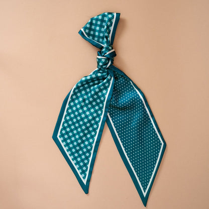 Twirl & Tie Scarf Accessory, A red and white gingham satin scarf tied in a knot, showing a red polka dot pattern on the reverse side of the tails.