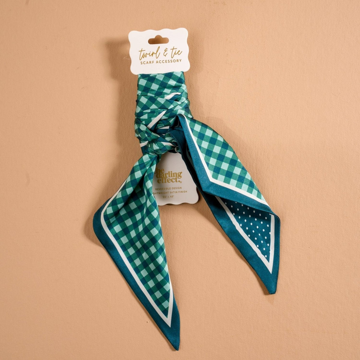 Twirl & Tie Scarf Accessory, A red and white gingham satin scarf tied in a knot, showing a red polka dot pattern on the reverse side of the tails.