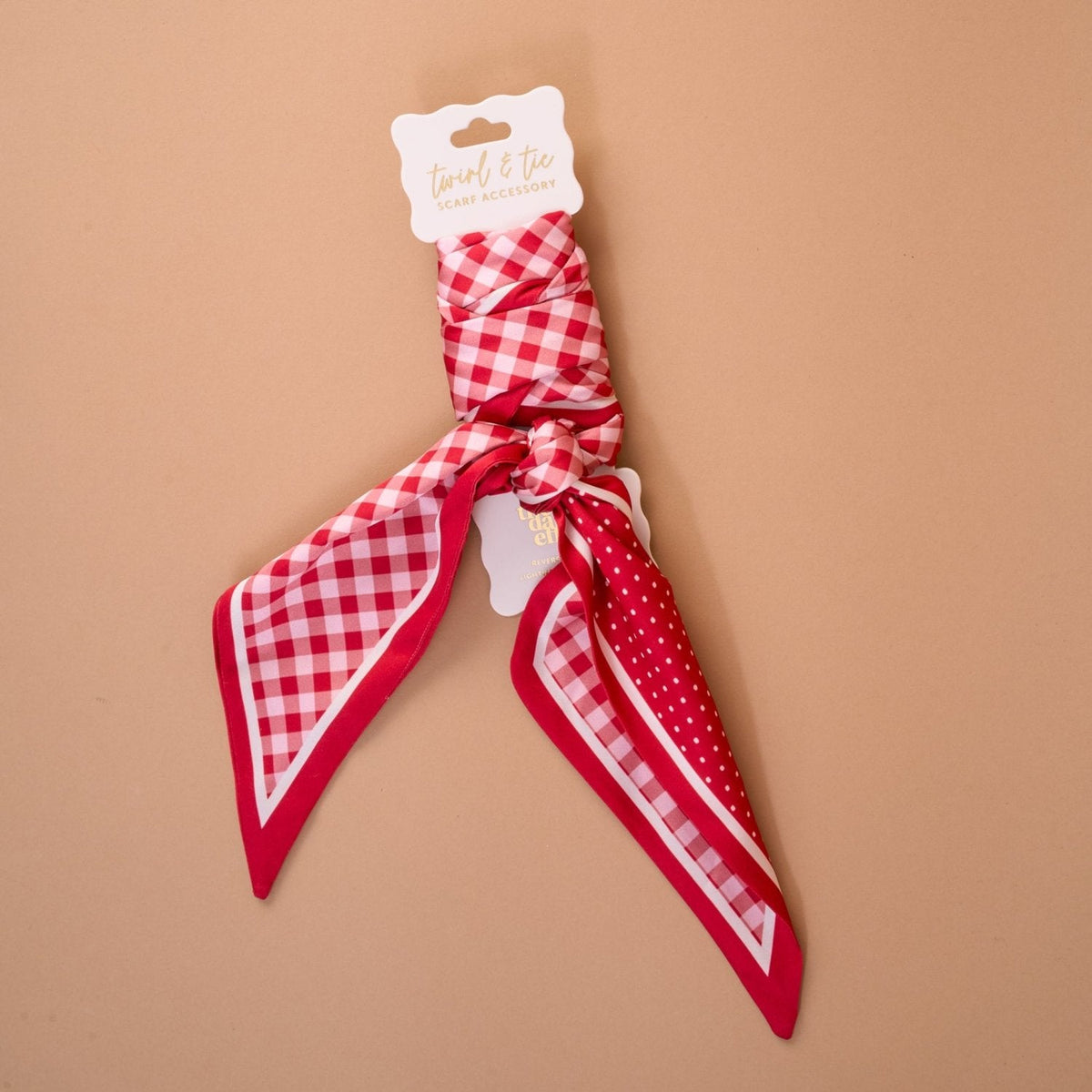 Twirl & Tie Scarf Accessory, A red and white gingham satin scarf tied in a knot, showing a red polka dot pattern on the reverse side of the tails.