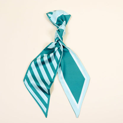Twirl & Tie Scarf Accessory, A red and white gingham satin scarf tied in a knot, showing a red polka dot pattern on the reverse side of the tails.