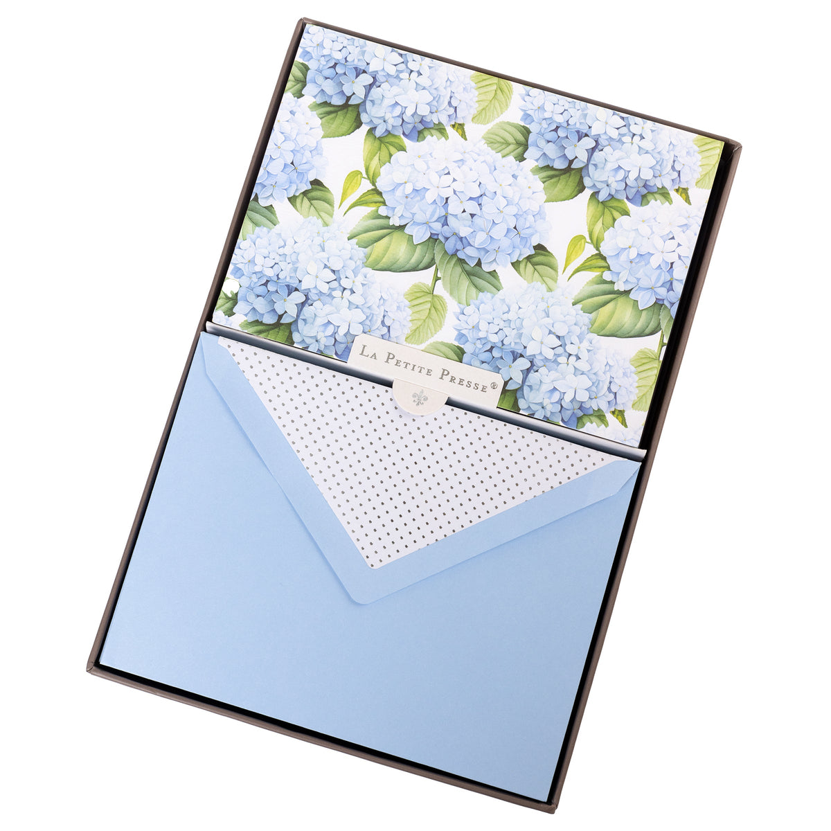 La Petite Presse Hortensia Boxed Correspondence Notes, A brown gift box open to a white notecard printed with powder blue hydrangea blooms, paired with a matching blue envelope.