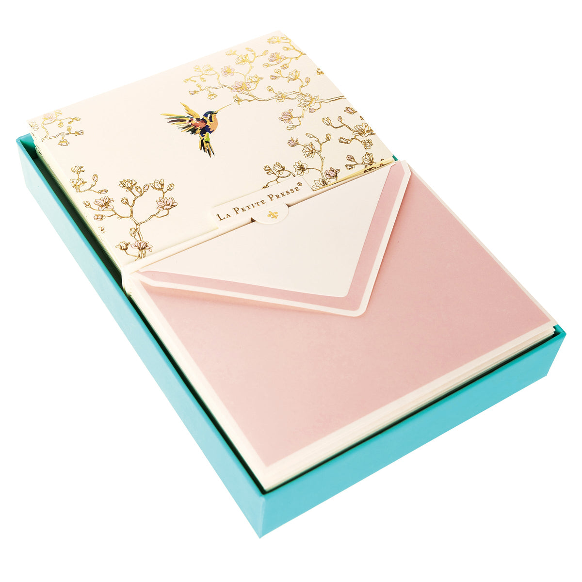 La Petite Presse Hummingbird Boxed Correspondence Notes, A cream notecard with a colorful hummingbird and gold magnolia branch line art, paired with a blush pink lined envelope.