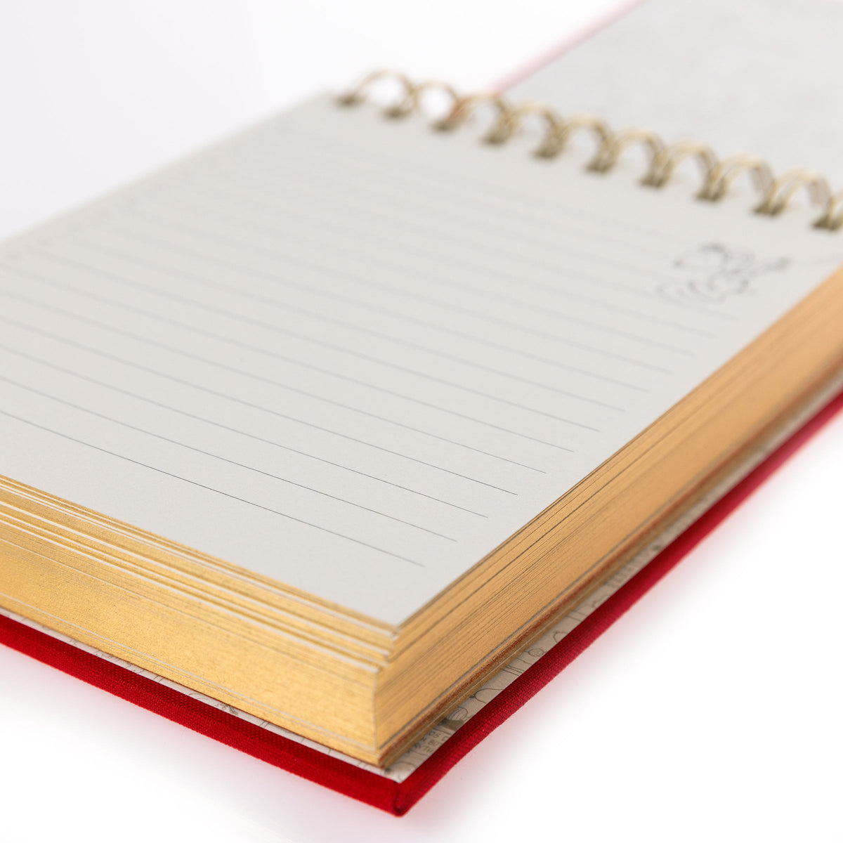 Peanuts Fabric-Bound Notepad, A red fabric-bound notepad with Snoopy typing at his typewriter in gold foil on the cover and gold gilded page edges.