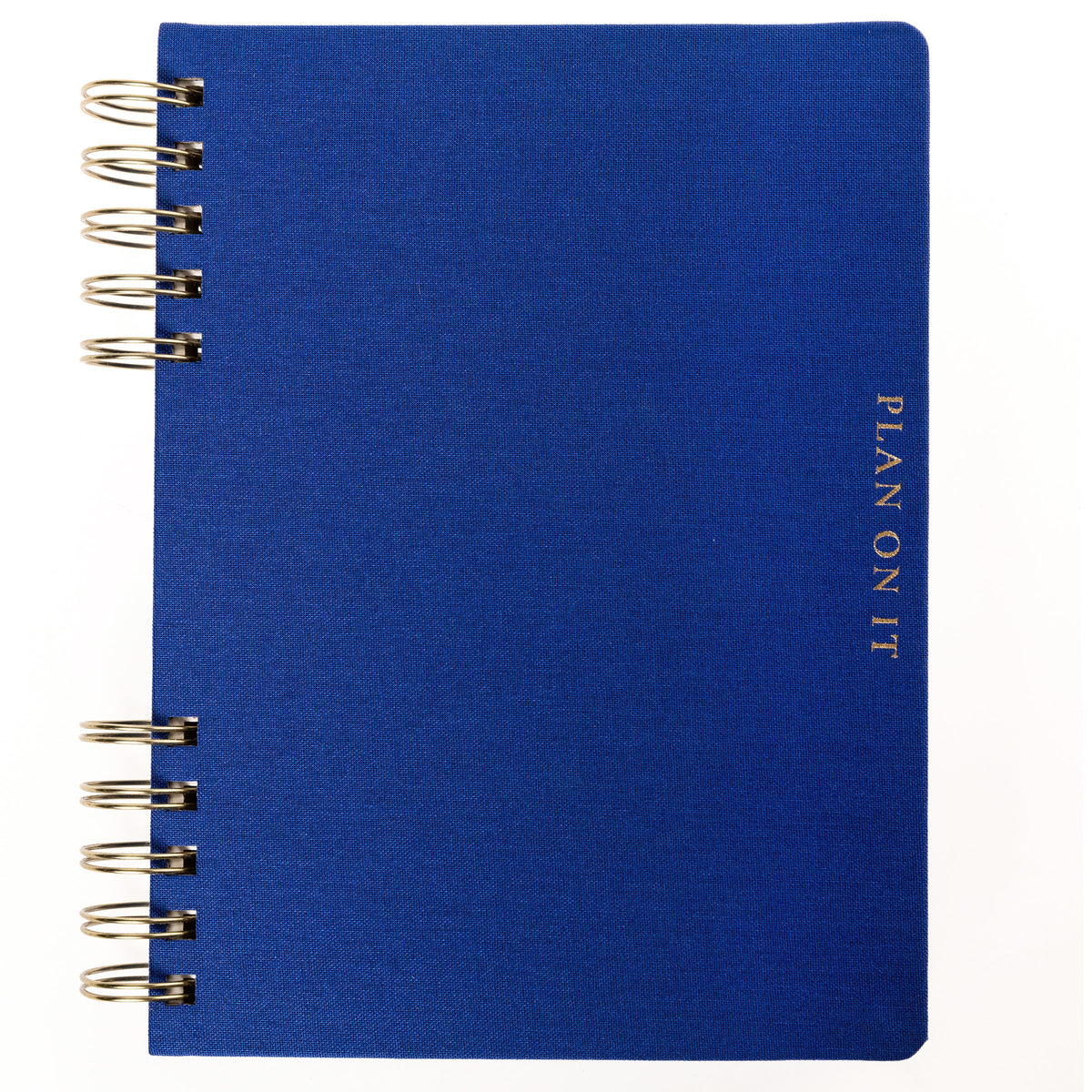 Cobalt Blue Fabric-Bound Task Journal, A cobalt blue fabric-covered task journal with gold twin wire spirals and two navy ribbon bookmark tabs, closed with an elastic band.