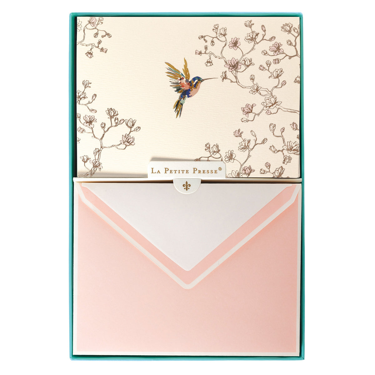 La Petite Presse Hummingbird Boxed Correspondence Notes, A cream notecard with a colorful hummingbird and gold magnolia branch line art, paired with a blush pink lined envelope.