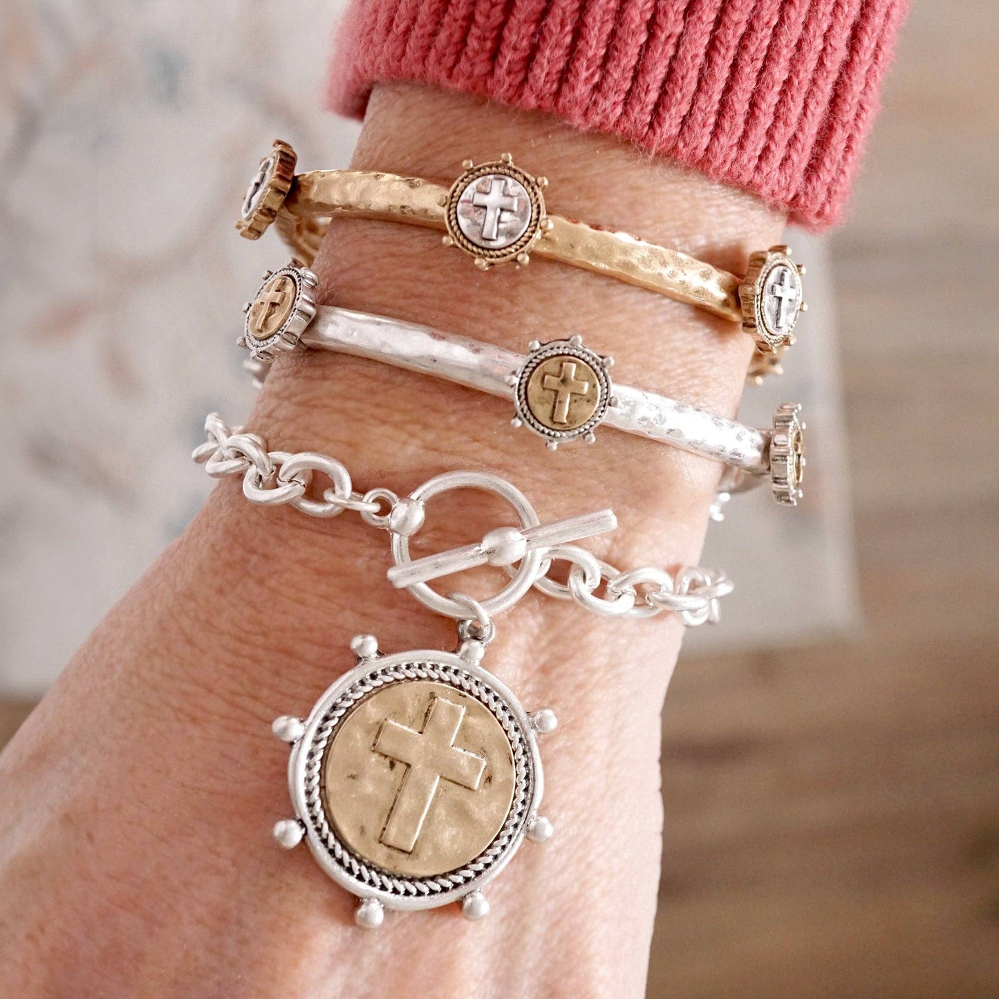 Pulsera de cadena con monedas cruzadas y cierre de palanca en tono plateado o dorado