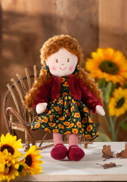 Amber Sunflower Rag Doll, A plush rag doll with copper curls in a black sunflower-print dress, a burgundy jacket and burgundy shoes.