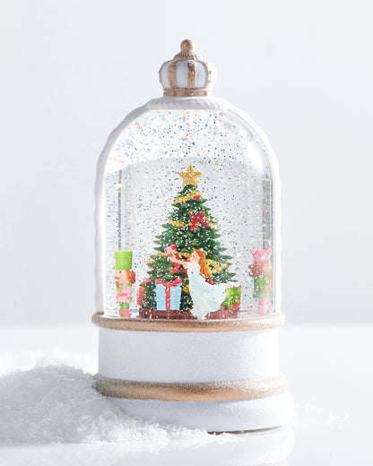 Animated Musical Nutcracker Suite Lighted Water Globe, A white and gold crowned water globe showing a rotating figure in a white dress beside a decorated Christmas tree flanked by two nutcracker soldiers.