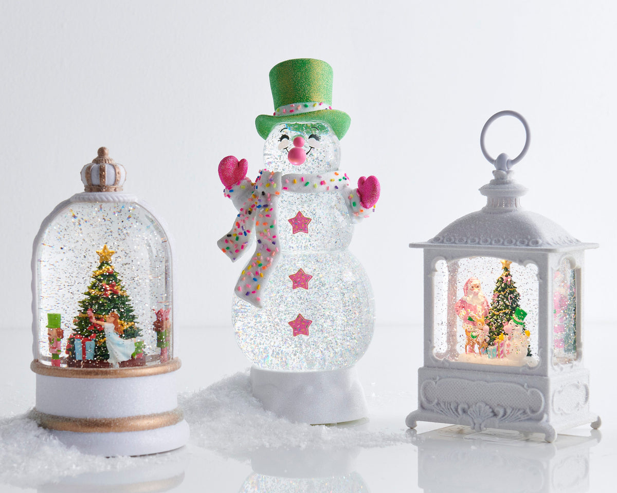 Animated Musical Nutcracker Suite Lighted Water Globe, A white and gold crowned water globe showing a rotating figure in a white dress beside a decorated Christmas tree flanked by two nutcracker soldiers.