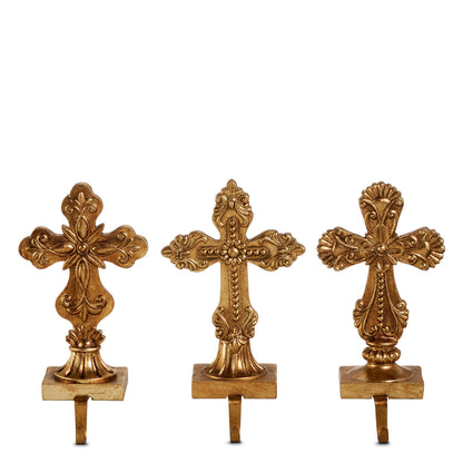 Antique Gold Holy Cross Stocking Holder, Three antique gold cross stocking holders side by side, each on a rectangular base with a hook, showing the rounded, beaded and shell cross designs.
