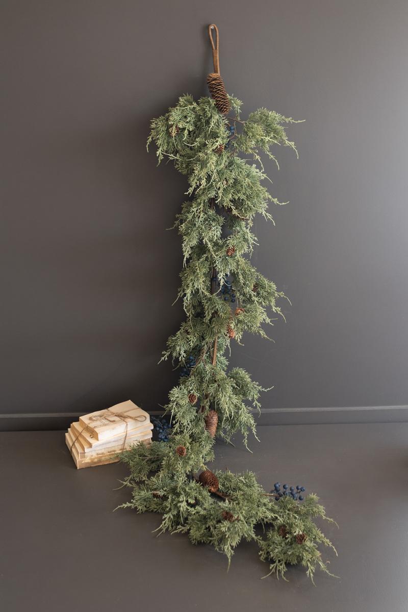 Artificial Juniper Christmas Garland with Berries, A faux juniper garland with red berries and pinecones laid out in a line.