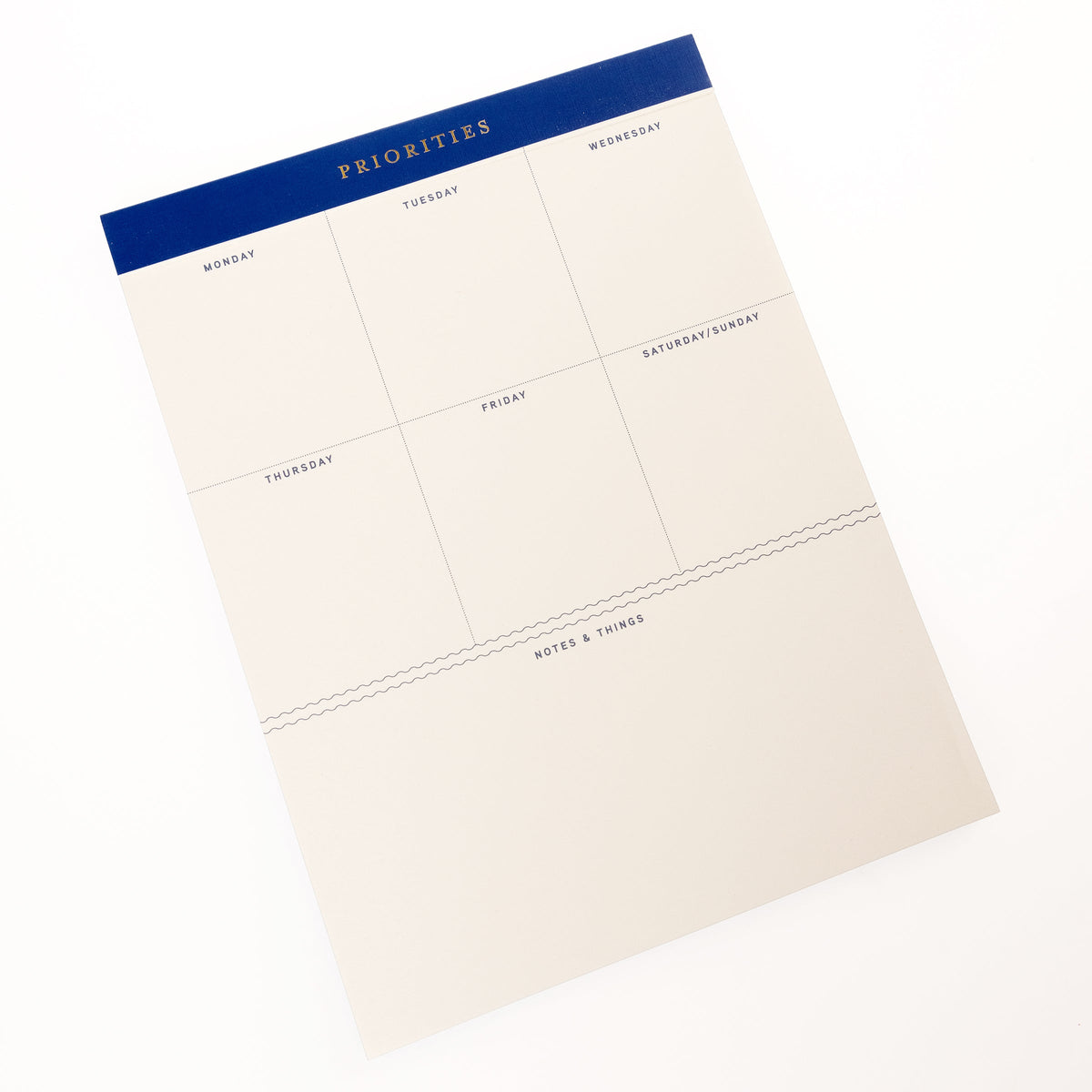 Cobalt Blue Legal Pad, A cream weekly planning pad with a cobalt blue header reading Priorities and a Monday through Sunday grid.