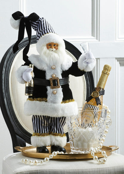 Black and White Champagne Santa, A standing Santa figurine in a black coat with white fur trim and a striped hat, holding a champagne bottle and glass.