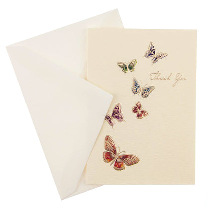 La Petite Presse Butterflies Boxed Notes, A cream Thank You card with six jeweled-tone foil butterflies rising toward gold script, tied with a tan ribbon inside a teal box.