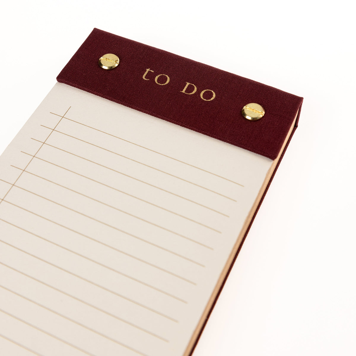 Burgundy Fabric-Bound Desktop Notepad, A burgundy fabric desktop notepad with to Do lettered in gold foil and two gold posts at the top.