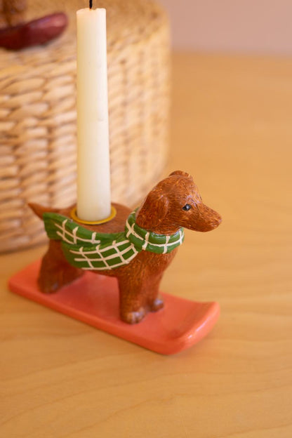 Ceramic Christmas Dog Taper Candle Holder, Five ceramic dog figures in holiday scarves, each holding a taper candle, lined up in a row.