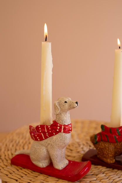 Ceramic Christmas Dog Taper Candle Holder, Five ceramic dog figures in holiday scarves, each holding a taper candle, lined up in a row.