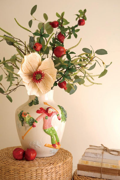 Ceramic Christmas Vase with Skier, A glossy ceramic vase with a painted skier figure wrapped around its side.