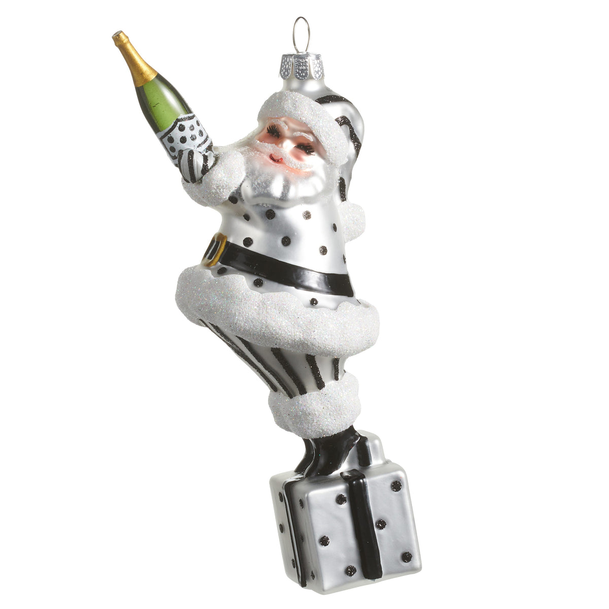 Champagne Popping Santa Ornament, A glass and resin Santa ornament in black and white polka dots, holding a champagne bottle while standing on a wrapped gift.