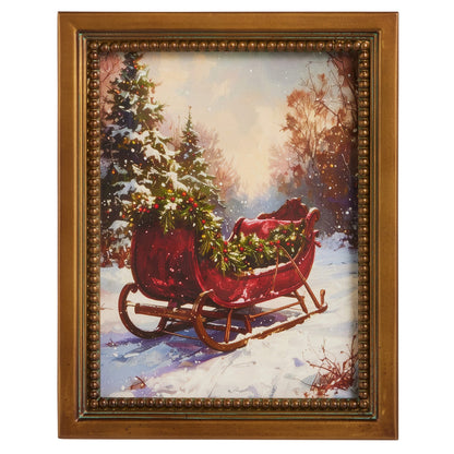 Christmas Sleigh Wall Art, A framed print of a red vintage sleigh loaded with a Christmas tree in a snowy woodland, in a gold beaded frame.