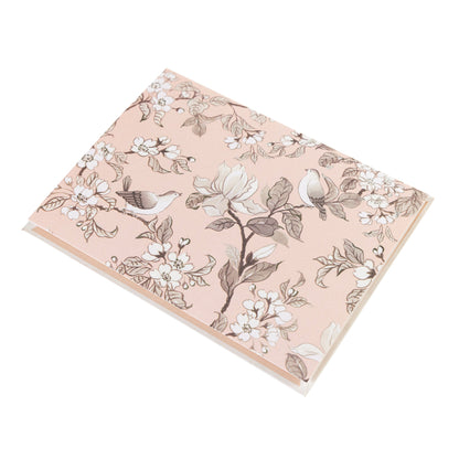 La Petite Presse Birds Boxed Correspondence Notes, A brown gift box open to a blush pink notecard printed with songbirds perched among magnolia blossoms, paired with a matching blush envelope.