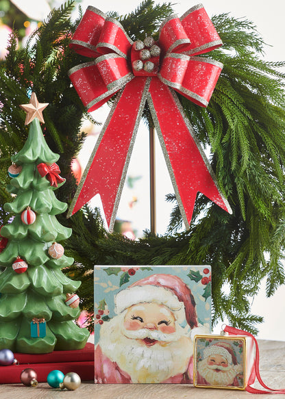 Decorated Ruffled Tree, A green resin tree with ruffled, tiered branches decorated with a red bow, pink and red ornaments, small teal wrapped gifts at the base, and a gold star on top.