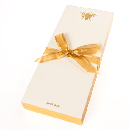 La Petite Presse Bee Gilded Desktop Notepad, A cream notepad with a gold foil bee at the top and the words Busy Bee stamped in gold at the bottom, with a gold gilded edge.