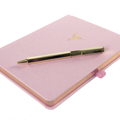 La Petite Presse Hummingbird Fabric-Bound Journal with Pen, A pink fabric journal with a gold foil hummingbird on the cover, paired with a gold twist pen tucked into a loop at the spine.