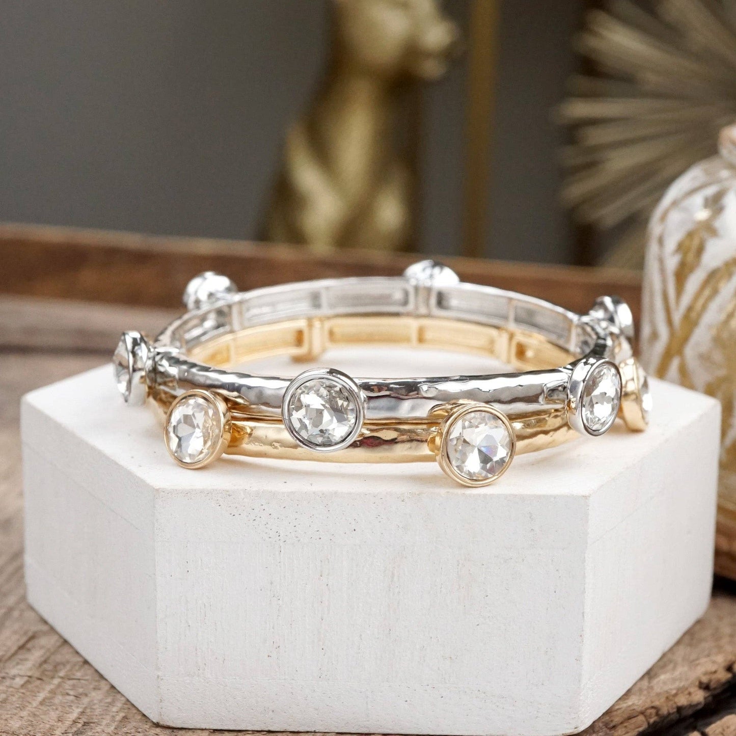 Brazalete de cristales transparentes brillantes en tono dorado o plateado.