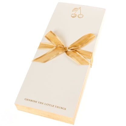 La Petite Presse Cherries Gilded Desktop Notepad, A cream notepad with gold foil cherries at the top and the words Cherish the Little Things stamped in gold at the bottom.