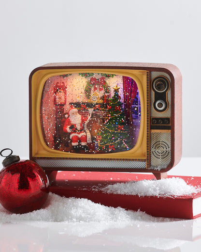 Fireplace Santa Musical Lighted Water TV, A vintage-style television shaped water lantern showing a glitter filled scene of Santa reading a list by a decorated fireplace and Christmas tree.