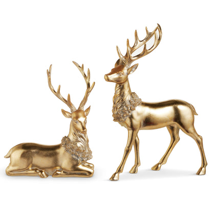 Gold Deer Figurine with Wreath, A lying gold resin deer figurine beside a standing one, each with tall antlers and a sculpted wreath around its neck.