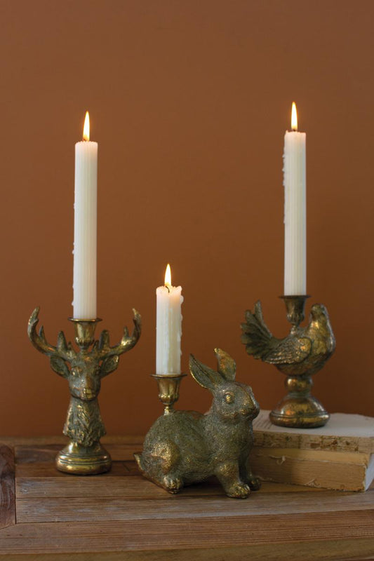Gold Deer Resin Taper Candle Holder, A gold resin deer figure with a taper candle holder set between its antlers.