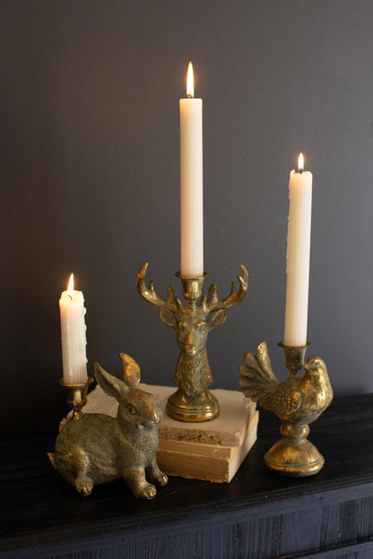 Gold Deer Resin Taper Candle Holder, A gold resin deer figure with a taper candle holder set between its antlers.