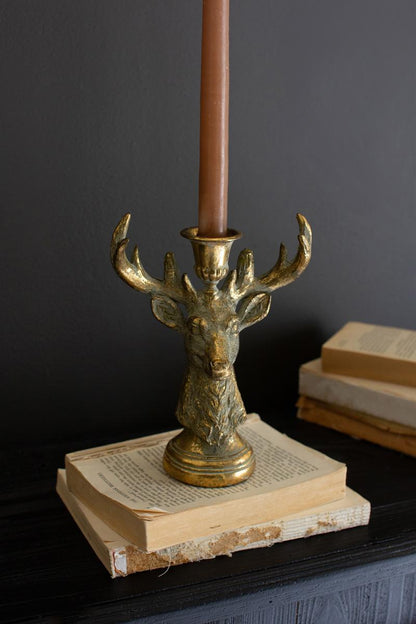 Gold Deer Resin Taper Candle Holder, A gold resin deer figure with a taper candle holder set between its antlers.