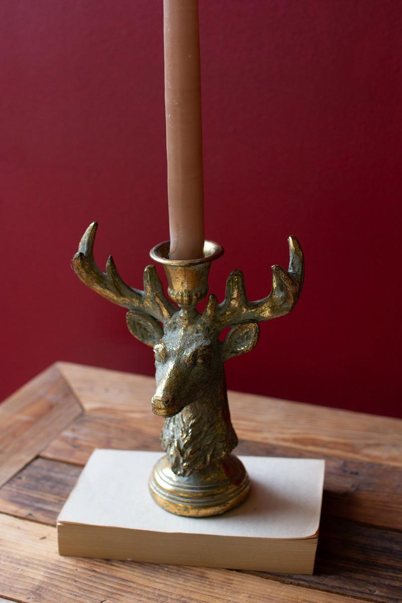 Gold Deer Resin Taper Candle Holder, A gold resin deer figure with a taper candle holder set between its antlers.