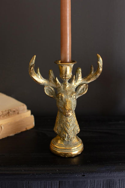 Gold Deer Resin Taper Candle Holder, A gold resin deer figure with a taper candle holder set between its antlers.