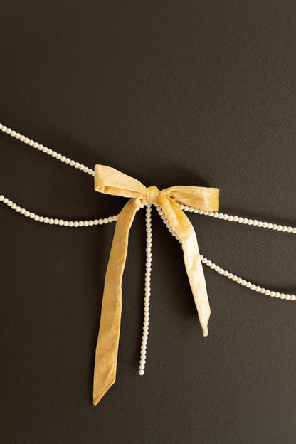 Gold Velvet Bow Garland with Faux Pearl Swag, A garland of velvet bows joined by gold rings with strands of faux pearls hanging between them.